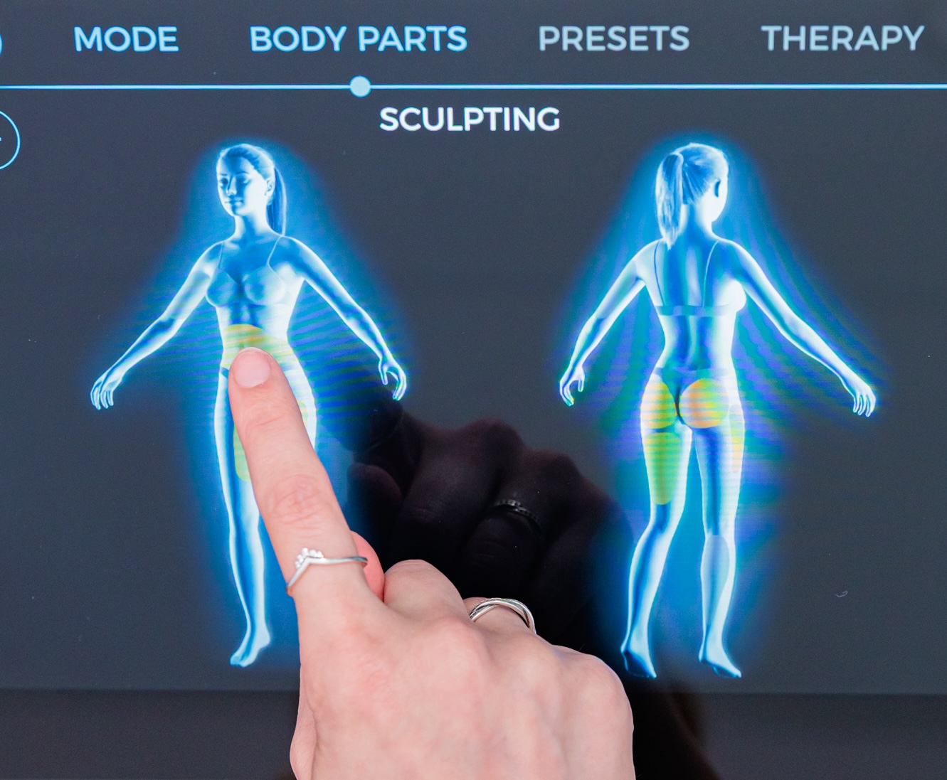 Closeup of a provider's hand adjusting the settings on the control panel of our Emsculpt NEO device. This is part of the client's pelvic floor therapy in Portage, MI.