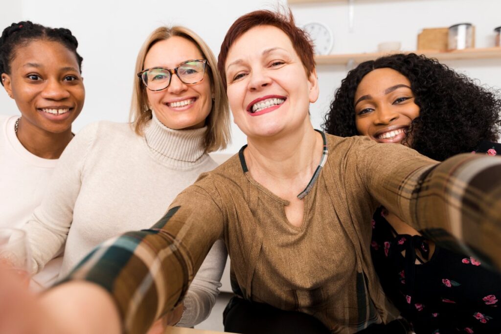 A woman takes a selfie with her friends, feeling more confident about socializing after having Emsella ramp-up her pelvic floor exercises in Portage, MI.
